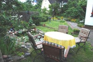 una mesa y sillas en un jardín con mesa y sillas en Ferienwohnung Christine, en Ostseebad Sellin