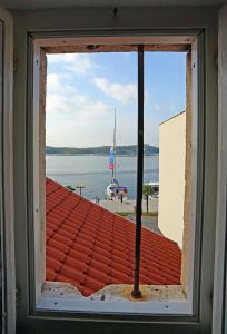 a window in a building with a view of the water at Swan Adriatic Apartment & Room in Šibenik
