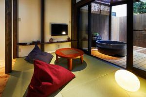 ein Wohnzimmer mit einer Badewanne und einer roten Couch in der Unterkunft Kiyomizu Inishie-an in Kyoto