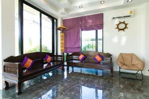 sala de estar con 2 sofás y reloj en SakSukSmile Resort, en Sukhothai