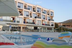 a hotel with a swimming pool in front of a building at Bara Bay in Metajna
