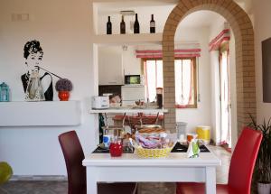ファヴァーラにあるB&B Vento di Sciroccoのキッチン(白いテーブル、赤い椅子付)