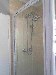 a shower with a glass door in a bathroom at Sea Gem in Big Bay