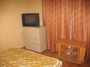 ヴォスクレセンスクにあるАпартаменты квартирного типаのベッドルーム(ベッド1台、ドレッサー内のテレビ付)