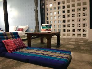 a living room with a laptop on a table and a couch at Kiri Tawan in Ban Tai