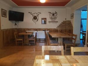 Un comedor con mesas y sillas y un televisor de pantalla plana. en Villa Tiha noc, en Vlašić