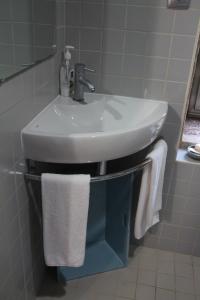 a white sink in a bathroom with towels at Casa Maria da Assunção in Vila Nova de Cerveira +19 photos