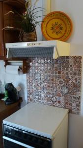 cocina con fogones y pared de azulejos en Anthi's Cottage, en Kastellánoi