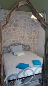 Una cama pequeña con almohadas azules. en Anthi's Cottage, en Kastellánoi