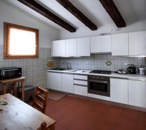 a kitchen with white cabinets and a table and a window at Casa Lunia in Mestre