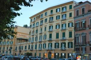 un grand bâtiment avec des voitures garées devant lui dans l'établissement Palazzo Mele Residence, à Naples
