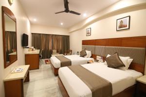a hotel room with two beds and a television at Daspalla Executive Court in Visakhapatnam