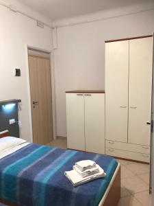 1 dormitorio con 1 cama con sábanas azules y armarios blancos en Albergo Chiara, en Savignone