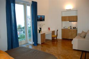 ナポリにあるPalazzo Mele Residenceのリビングルーム(デスク付)、キッチン(窓付)