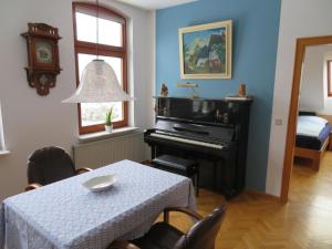 een eetkamer met een tafel en een piano bij FEWO am Dümmer-See in Lembruch