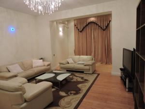 uma sala de estar com dois sofás e uma televisão em 1 Shota Rustaveli Avenue em Tbilisi