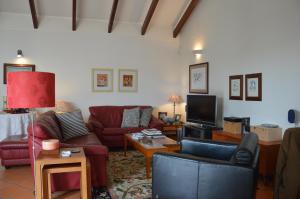 a living room with couches and a tv at HOMEinLAND of TERROSO - Privat Pool, Grill & Seaview in Póvoa de Varzim