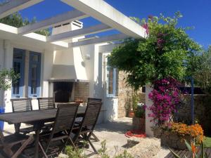 a patio with a table and chairs under a pergola at HOMEinLAND of TERROSO - Privat Pool, Grill & Seaview in Póvoa de Varzim