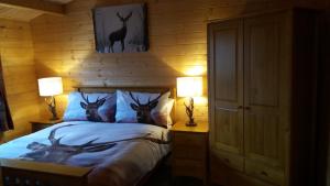 a bedroom with a bed with three deer heads on it at Lochinvar - Highland Log Cabin with Private Hot Tub in Airdrie