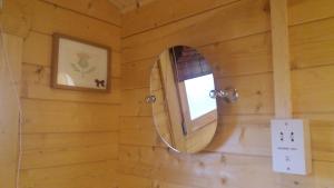 a mirror in a wooden room with a window at Lochinvar - Highland Log Cabin with Private Hot Tub in Airdrie +10 photos