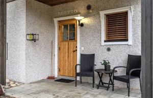 una puerta delantera de una casa con 2 sillas y una mesa en Vuokatti Weekend Studio, en Vuokatti