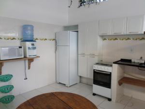 a white kitchen with a refrigerator and a stove at Casa para temporada in Prado