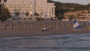una spiaggia con sedie e barche sulla sabbia di Hotel Abruzzo Marina a Silvi Marina