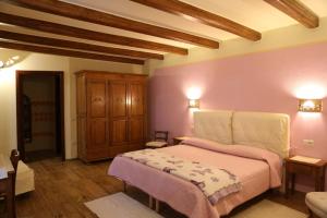 1 dormitorio con 1 cama con paredes de color rosa y suelo de madera en Funtanedda, en Teti