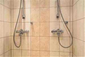 a shower with two faucets on a tiled wall at Vuokatti Weekend Lux in Vuokatti +37 photos