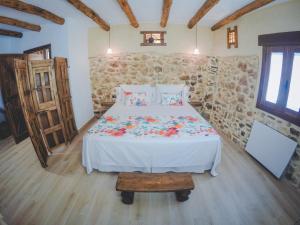 1 dormitorio con cama y pared de piedra en Navazos loft, en Benaocaz