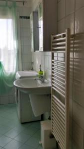 ein weißes Badezimmer mit einem Waschbecken und einem Spiegel in der Unterkunft Residence Flavia in Mogliano Veneto