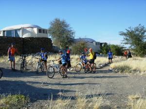 un grupo de personas montando bicicletas en un camino de tierra en Rostock Ritz Desert Lodge, en Cha-re