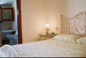 a bedroom with a bed and a bathroom with a toilet at B&B Porto Romano in Olbia