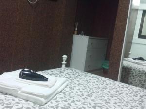 a black cell phone sitting on top of a bed at Jualis Guest House in Porto