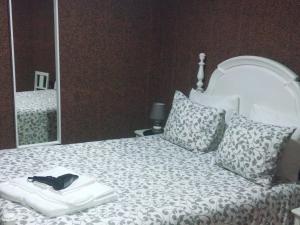 ein weißes Bett mit einem schwarzen Schuh darüber in der Unterkunft Jualis Guest House in Porto