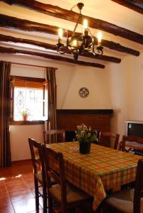 uma sala de jantar com uma mesa com cadeiras e um lustre em alojamiento rural la ermita bubion em Bubión