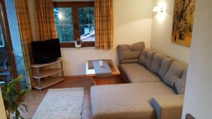 a living room with a couch and a tv at Pension Lischenhof in Ehrwald