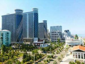 a city with tall buildings and a street with trees at Olympic Batumi in Batumi