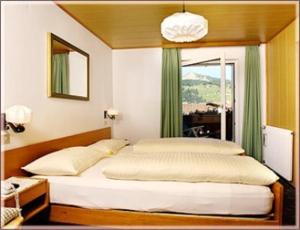 1 dormitorio con 1 cama grande y ventana en Garni Sayonara en Selva di Val Gardena