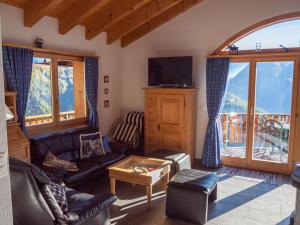 ein Wohnzimmer mit einem Sofa und einem TV in der Unterkunft Chalet Bergkristall in Rosswald