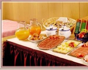 uma mesa com alimentos e bebidas para o pequeno almoço em Garni Sayonara em Selva di Val Gardena