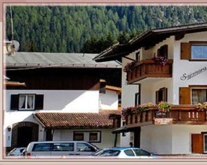 a building with cars parked in front of it at Garni Sayonara in Selva di Val Gardena
