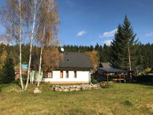 a white house in a yard with trees at Harrachov 571 in Harrachov