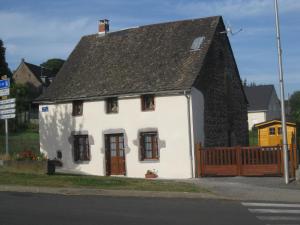 a small white house with a brown roof at La petite maison in Tauves