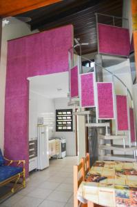 cocina con paredes de color púrpura y mesa en una habitación en Condomínio Higa en Peruíbe