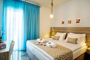 Un dormitorio con una cama grande con cortinas azules. en Beachside Apartment in Plakias centre!, en Plakias