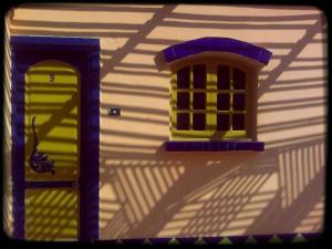 a toy house with two windows and a shadow at Neptune Hotel in Dahab