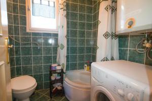 a bathroom with a toilet and a washing machine in it at Vacation home Miki in Bajina Bašta +54 photos
