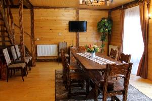 een eetkamer met een houten tafel en stoelen bij Szlachta Cottage in Boekovel