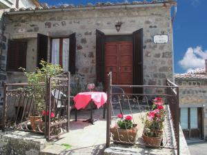 a house with a table and flowers in front of it at Casa della piazza in Radicofani